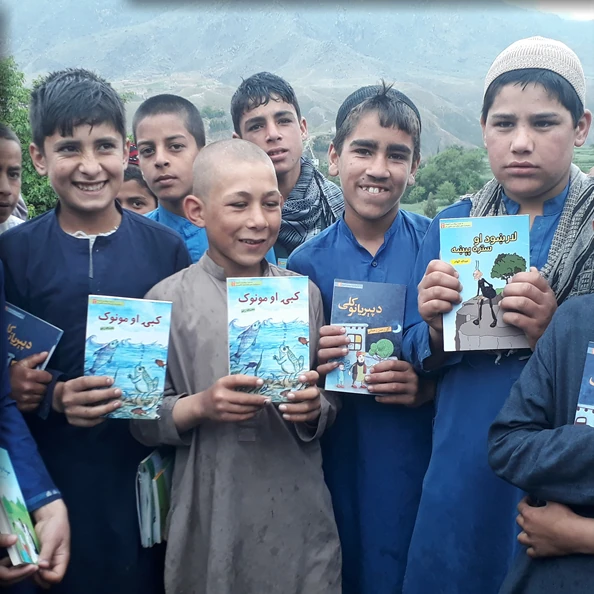 Boys holding ABLE books outdoors