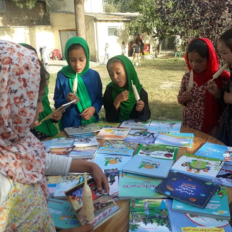 Girls choosing books from a box library